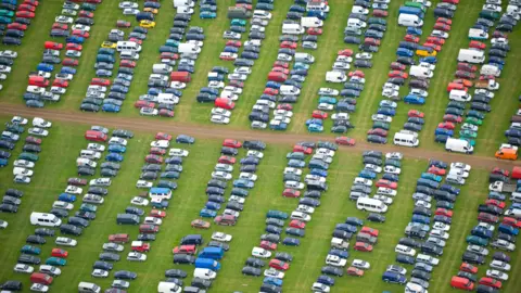 Getty Images Image of cars parked in a field at Glastonbury