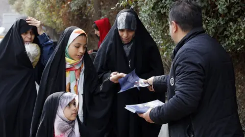 EPA Iranian campaign workers hand out electoral leaflets for a candidate in the upcoming parliamentary polls, in Tehran, Iran (23 February 2024)