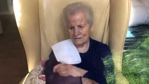 Martina Ferguson Ursula Derry, pictured through the window of her care home bedroom earlier this month