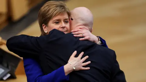 Reuters Swinney Sturgeon hug