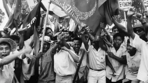 Getty Images Young people holding flags with Arabic inscriptions