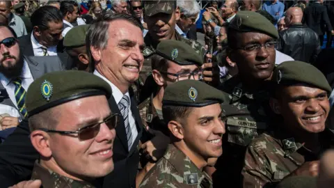 Getty Images Jair Bolsonaro poses with members of the military