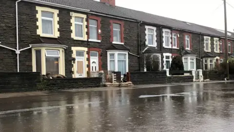 Flooded road and sandbags in Oxford Street in Nantgarw