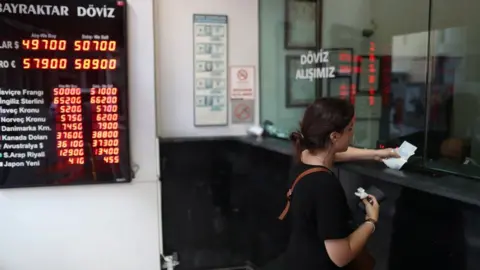 EPA A woman exchanges money at a currency exchange office in Istanbul, Turkey.