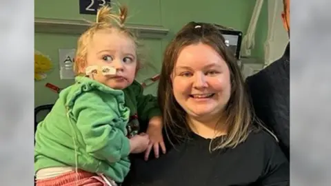 Family handout A women holding a baby in a green top