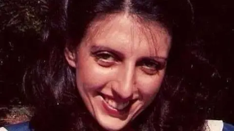 A family photograph of Eunice Jones, who has long, dark hair and brown eyes and is smiling at the camera