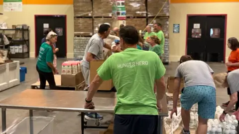 Volunteers packing boxes in a warehouse