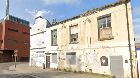 LDRS The crumbing and shuttered up white pub, viewed from the street