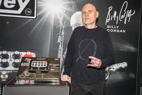 Getty Images Billy Corgan of Smashing Pumpkins poses with a Laney Supergrace amplifier. he is wearing a black jumper and jeans 