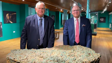 Highlands College Chairman of the Highlands Foundation, David Lord and His Majesty’s Receiver General for Jersey, Alan Blair at the display of the hoard at Le Hougue Bie