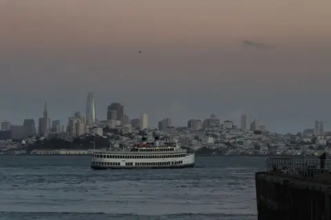 Getty Images A ferry crosses the San Francisco Bay at sunset