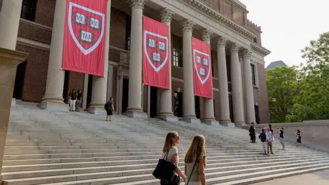 Red flags with the Harvard crest hang over The Widener Library on the Harvard Campus in Cambridge, Massachusetts.