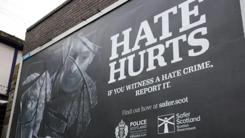 Getty Images A billboard promoting the Hate Crime and Public Order Act in Scotland, with HATE HURTS written in large white letters on a black background.