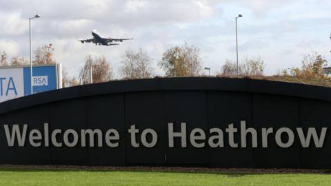 Picture shows Welcome to Heathrow sign with plane taking off in the background