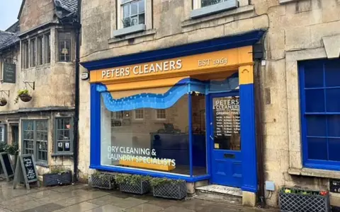 An orange and blue painted shopfront on a stone building.