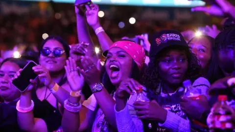 Getty Images Women cheering at a concert in Johannesburg - December 2024