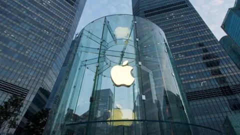 Getty Images The apple logo on a clear round store is visible in amongst the skyscrapers in a city