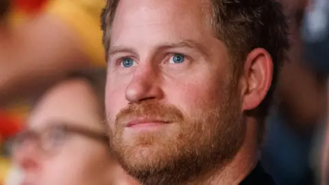 Getty Images A adjacent  changeable  of Harry's look   softly smiling during the closing ceremonial  of the Invictus Games Düsseldorf 2023