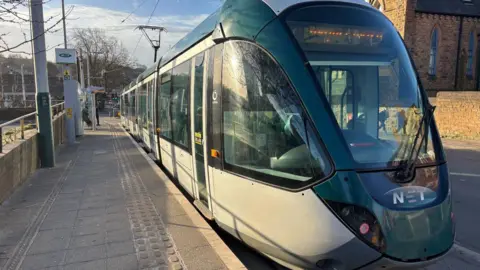 A Nottingham Express Transit tram at a stop in Nottingham 