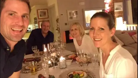 Walker family (From right to left) Amanda Walker, Glenda Walker, her father and brother, sitting around a dinner table with wine glasses and food on plates