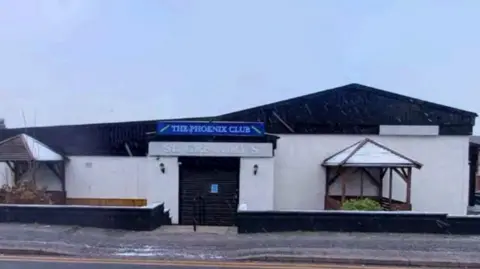 Local Democracy Reporting Service A low set white building with a sign that reads 'The Phoenix Club' and 'St Gregory's' as seen from a street. 