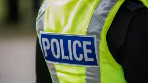 Getty Images A close up of a police officer in a black t shirt and a high vis police vest