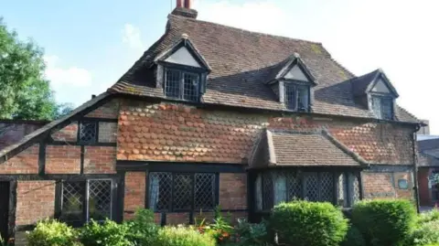 Cranleigh Leisure Trust A historic building with brown tiles, beams and leaded windows