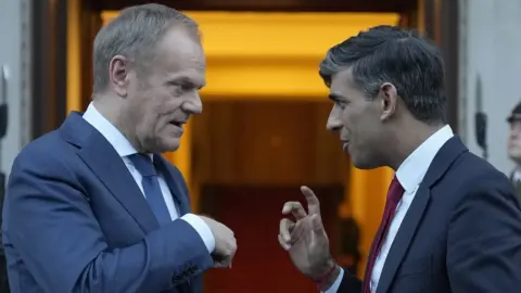 PA Media Prime Minister Rishi Sunak (right) chats with Poland's Prime Minister Donald Tusk before he leaves Warsaw, Poland.
