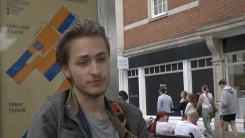 Meghan Shaw/LDRS A man in a grey jacket and shirt. He is standing at a busy high street.