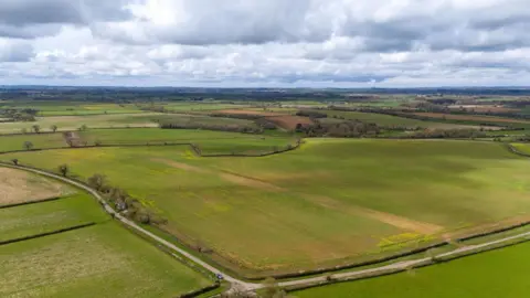 PA Media Drone shot of green countryside in north Wiltshire with fields bordered by fencing and hedgerows