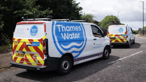 Two vans parked on the roadside with 'Thames Water' written prominently on the side.