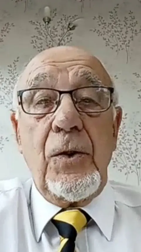 A veteran, dressed in a shirt and tie, discussing how he was sent to christmas island for nuclear teasting in the 1950's