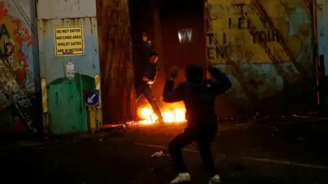 Reuters Protesters are seen at the "peace wall" gate into Lanark Way as protests continue in Belfast, Northern Ireland