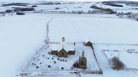 PA Media Snow covering a church and surrounding fields.