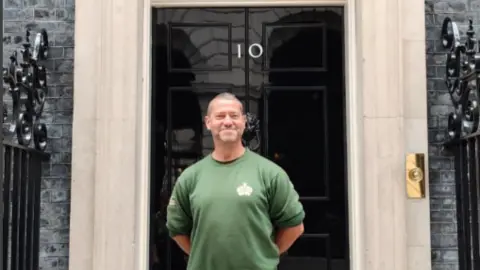 Karl Stevens Smiling Karl Stevens, wearing a green gardening jumper, poses outside the door of No.10 Downing Street