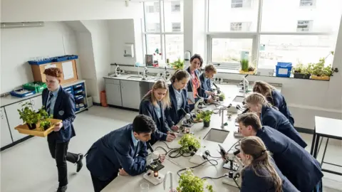 Getty Images Children in science class looking down microscopes