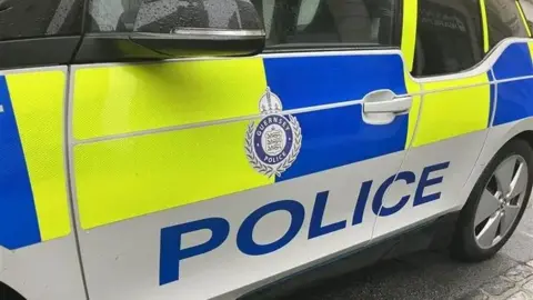 A Guernsey police car with yellow and blue livery.