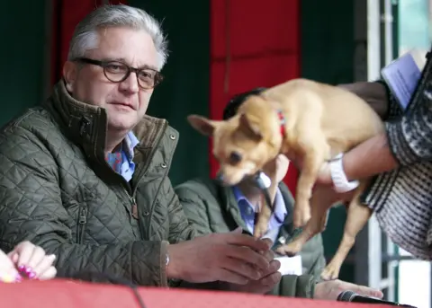 AFP/Getty Images Prince Laurent of Belgium is presented with a small dog while judging a dog show in 2014