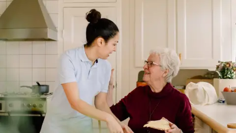 Getty Images Elderly lady with home carer