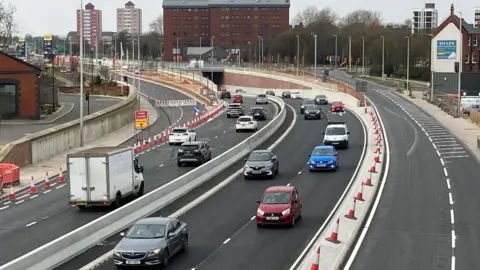 Multiple vehicles travelling in both directions on the new A63 underpass.