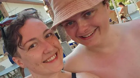 Ben Smith Music A selfie-style image of Lauren and Ben Smith. Lauren has sunglasses on her head and Ben is wearing a hat. They are both smiling and looking into the camera.