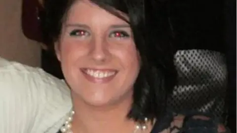 Wiltshire Police Sian O'Callaghan in a family photo. She has shoulder-length dark hair and is wearing a pearl necklace. She is smiling.