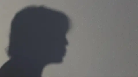 A silhouette of a woman on a white wall 