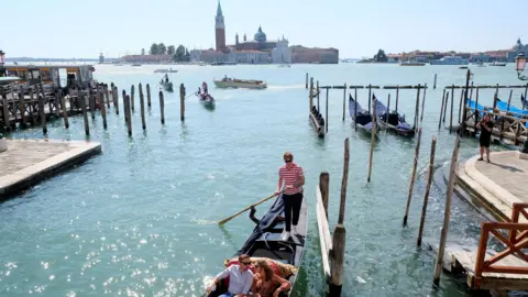 Reuters People ride on a gondola as the municipality prepares to charge tourists up to 10 Euro for entry into the lagoon city, in order to cut down the number of visitors, in Venice, Italy, September 5, 2021. 