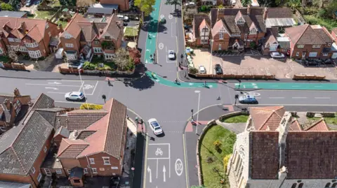 A 3D visual image of a birds eye view of Stroud Road adjoining King Edwards Avenue in Gloucester, A green cycle path runs through some of the road.