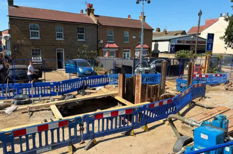 BBC Roadworks shows hole in ground and red/white/blue fences around it 