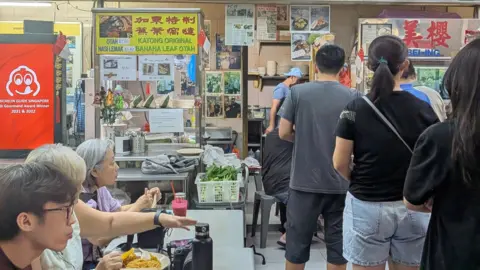 People line up at nearby shop at the food centre on Monday 