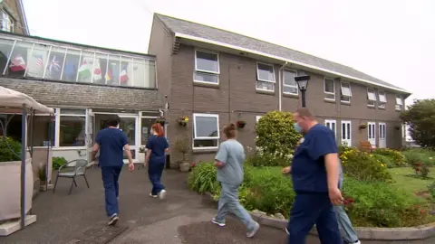 BBC Care home staff walking in to work