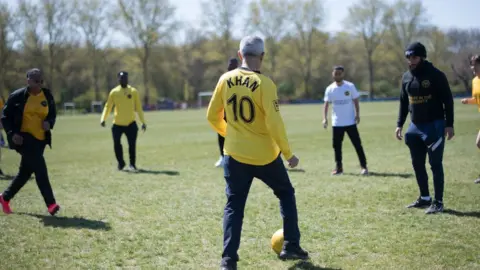 PA Media Sadiq Khan plays football with members of Hackney Wick FC