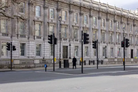 Getty Images A lone man crosses Whitehall and Parliament street during the middle of the day towards the Cabinet Office in Westminster